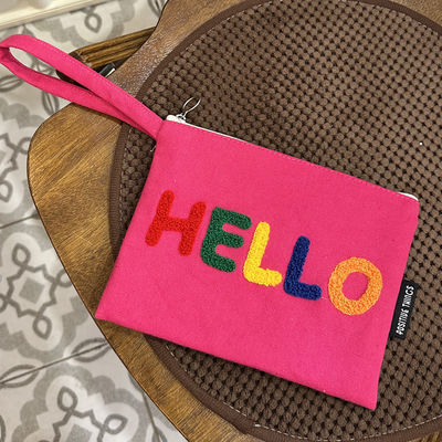 Une lettre brodée en couleurs, un sac à l'épaule, un choix fonctionnel et à la mode