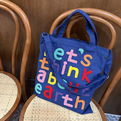 Une lettre brodée en couleurs, un sac à l'épaule, un choix fonctionnel et à la mode