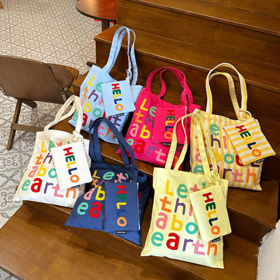 Une lettre brodée en couleurs, un sac à l'épaule, un choix fonctionnel et à la mode