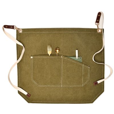 Les hommes travaillent sur le tablier avec des poches d'outils et des couleurs personnalisées sur une toile à moitié corps