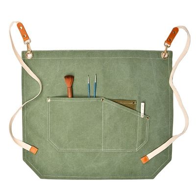 Les hommes travaillent sur le tablier avec des poches d'outils et des couleurs personnalisées sur une toile à moitié corps