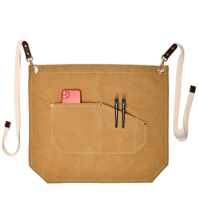 Les hommes travaillent sur le tablier avec des poches d'outils et des couleurs personnalisées sur une toile à moitié corps