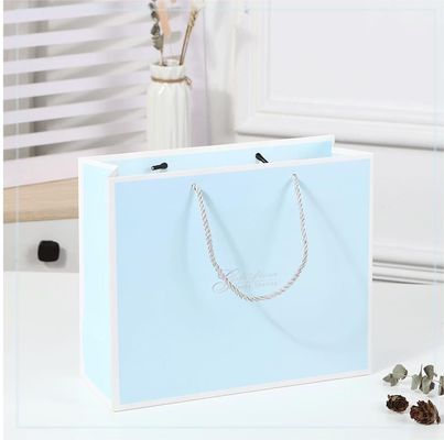 Sac de magasinage imprimé sur mesure en carton Sac cadeau en papier kraft blanc de luxe avec poignée de ruban