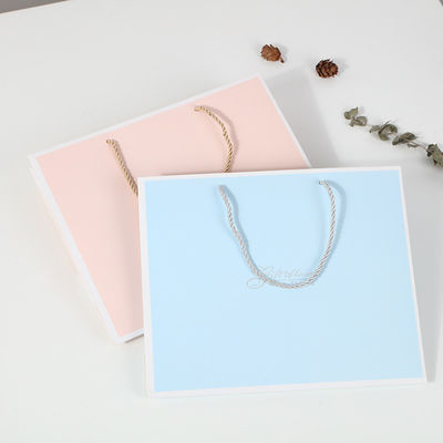 Sac de magasinage imprimé sur mesure en carton Sac cadeau en papier kraft blanc de luxe avec poignée de ruban